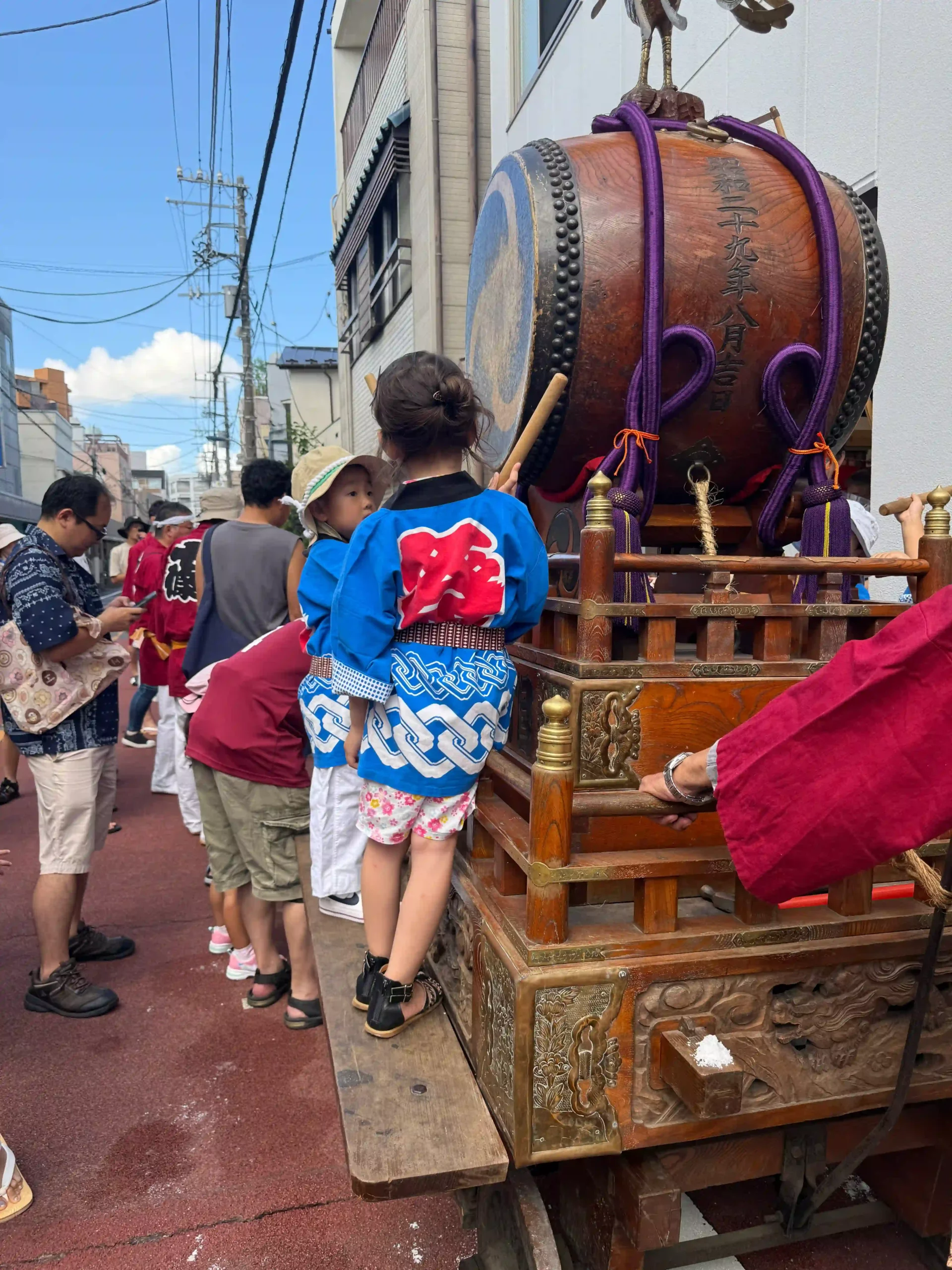 Enfant de 5 ans sur le dashi jouant du taiko lors d'un matsuri de quartier à Tokyo