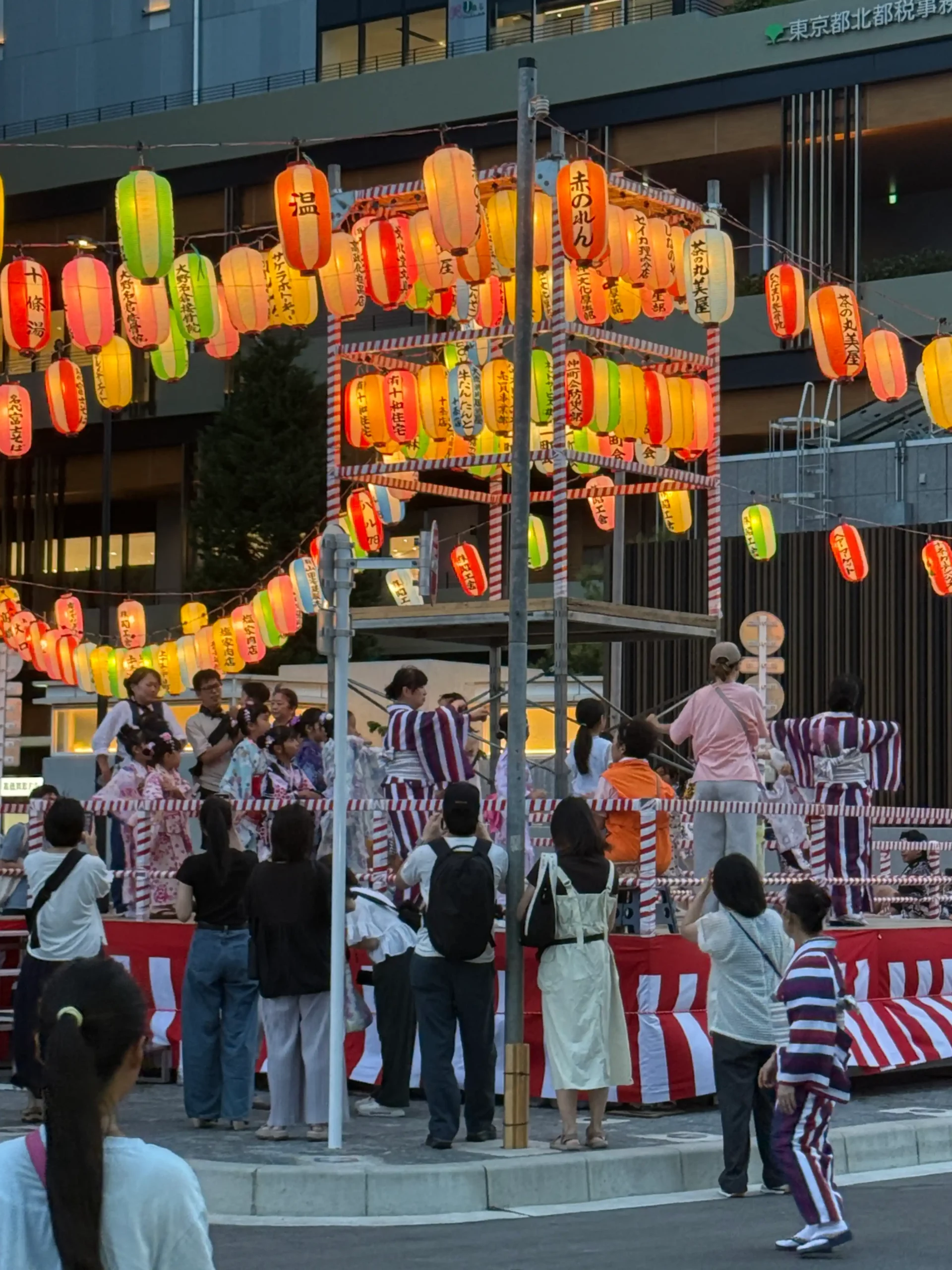 Habitants réunis sur la place du quartier pour le Bon Odori, certains en kimono, lors du matsuri estival