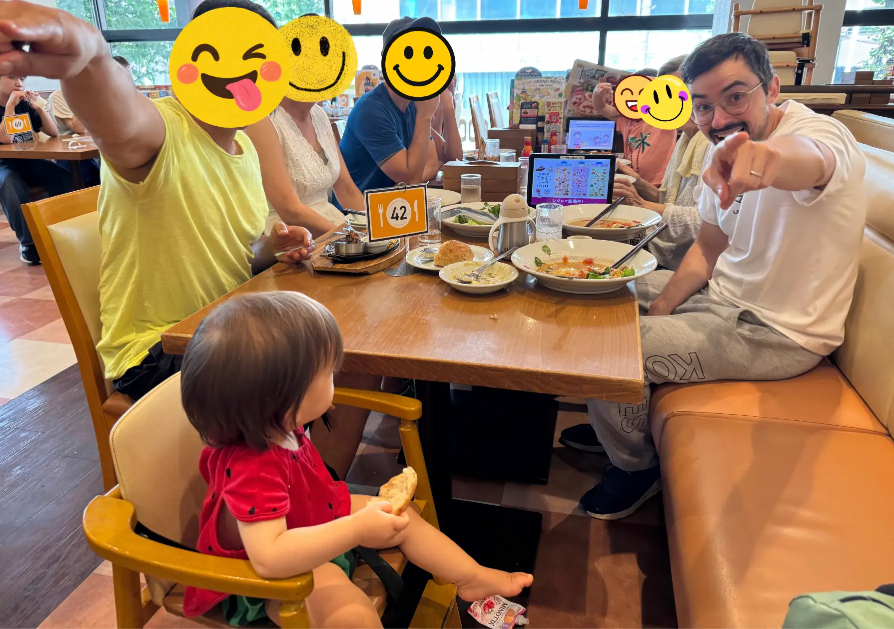 Repas en famille dans un famiresu japonais : bébé dans une chaise haute, tablette de commande tactile sur la table, famille autour