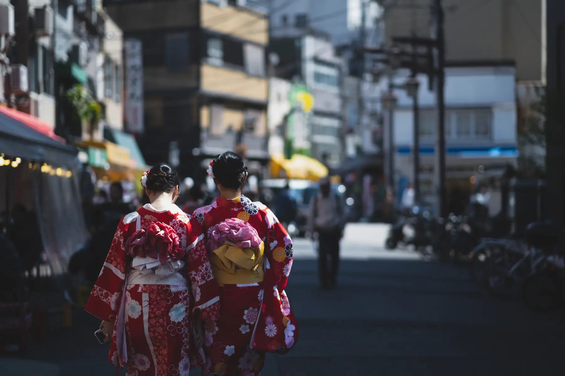 Deux femmes en kimono rouge marchant dans une rue d’Asakusa, Tokyo
