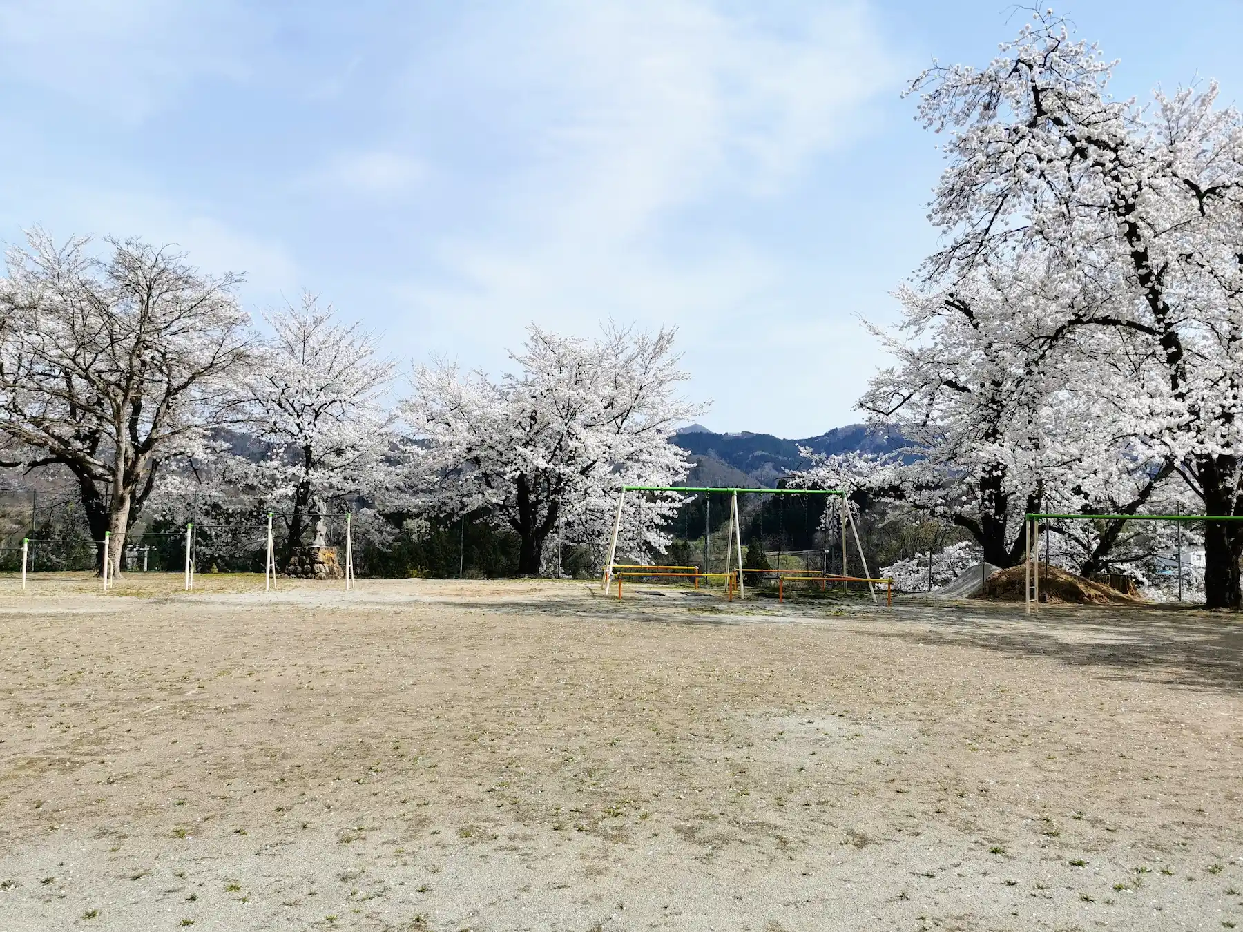 Cour d'école de montagne à Yamagata, cerisiers et montagnes en fond