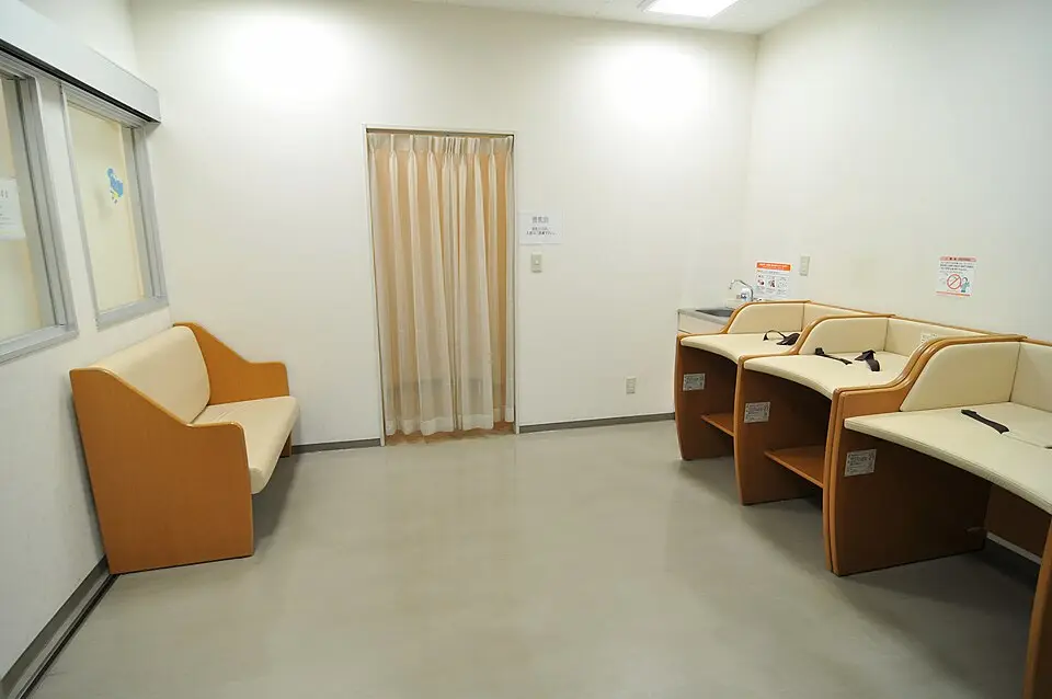 Salle d'allaitement japonaise (授乳室) avec postes individuels et cabine à rideau dans un bâtiment public