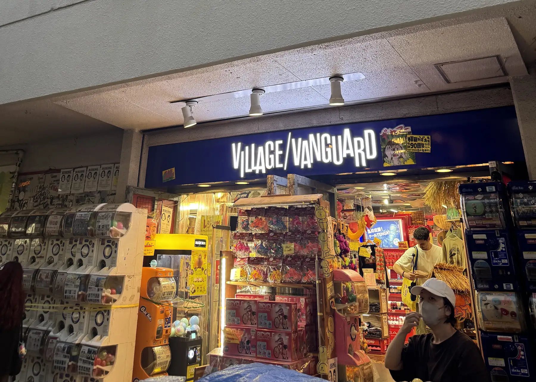 Devanture du Village Vanguard Shimokitazawa avec enseigne bleue et machines gacha devant l entrée du magasin